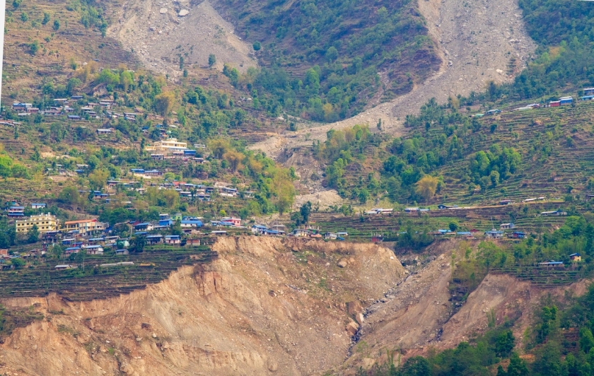 A close up view of a damaged hillside and some houses